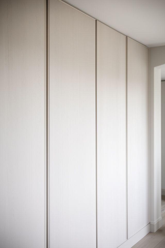 Private Residenz mit hellen Wandpaneelen, dezenten Fugen und ruhiger, eleganter Materialwirkung